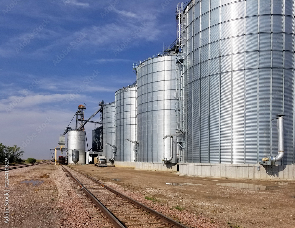 bright shinning metal grain elevators next to railroad tracks, Wall, SD, USA bright shinning metal grain elevators next to railroad tracks, Wall, SD, USA