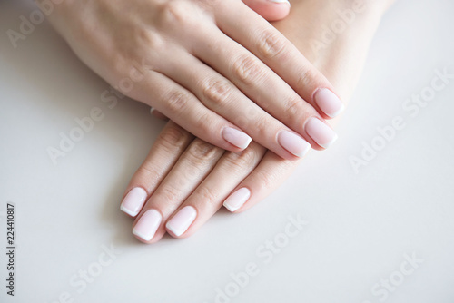 Manicured hands on towel. French manicure.