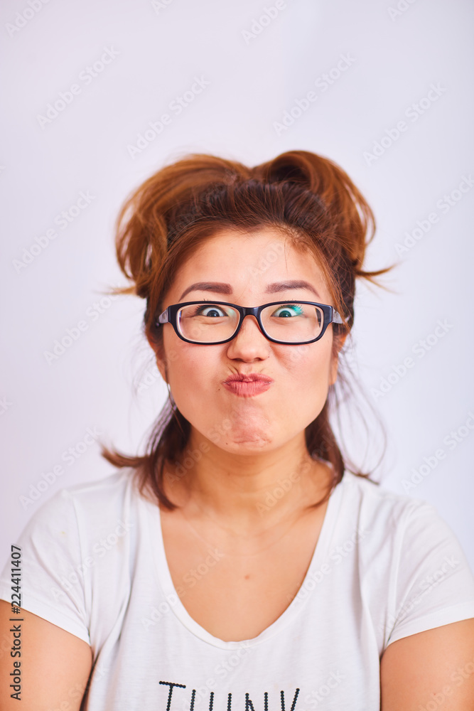 The girl with glasses clasped her lips and looks with cunning eyes The girl with glasses clasped her lips and looks with cunning eyes