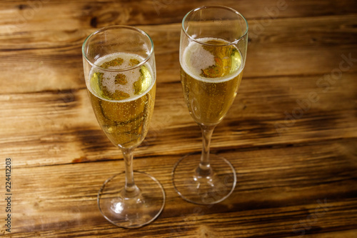 Two glasses of champagne on wooden table