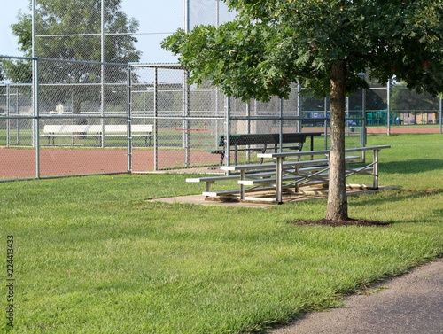 Photography The metal bleachers under the trees at the baseball fields.