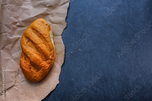 bread on the table just from the stove. Freshly baked bread on kraft paper on a dark background.