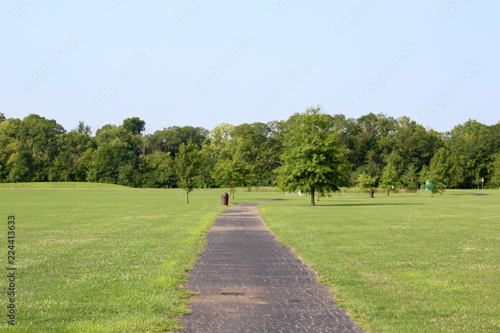 A long winding blacktop pathway in the park.