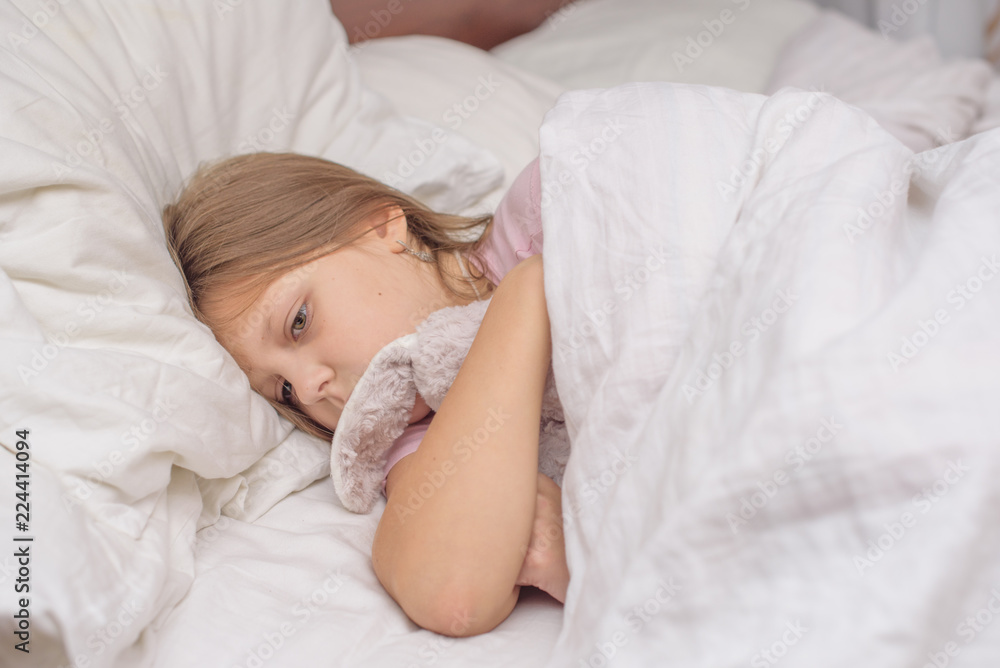 little girl lying in bed with abdominal pain, painful disease, feeling unwell, ache concept little girl lying in bed with abdominal pain, painful disease, feeling unwell, ache concept