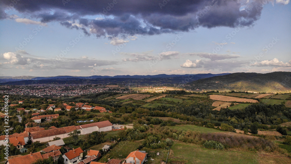 Aerial view of beautiful autumn sunset with a lot of clouds. Amazing colors and shadows of the clouds on the land. Landscape of village in Sumadija near the Kragujevac.