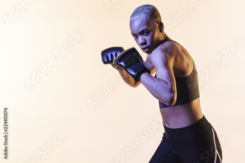 Young woman boxing, against a blank studio background