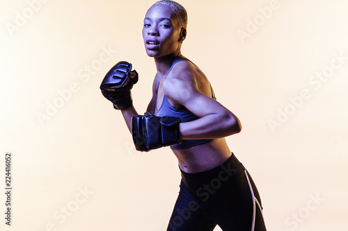 Young woman boxing, against a blank studio background