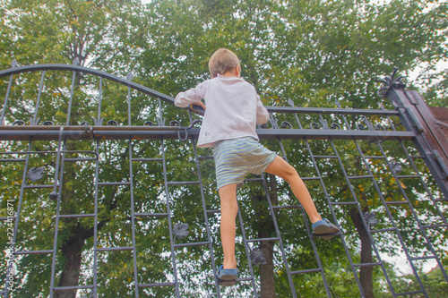 The boy climbed onto the fence. The child climbs on the gate, fence.