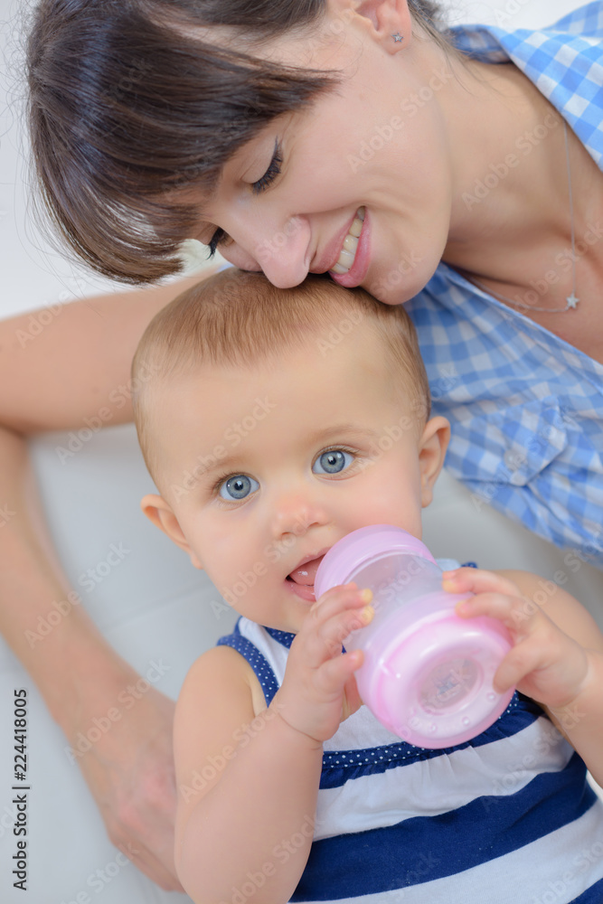 mom feeds the baby from the bottle with teat mom feeds the baby from the bottle with teat