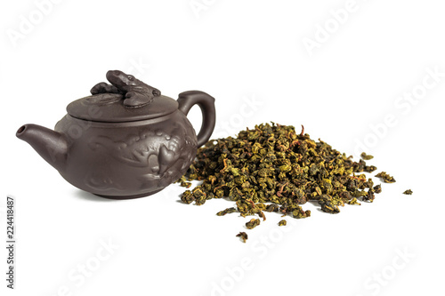 dry leaves of tea tieguanyin, scattered around a porcelain teapot, a tea blade.
