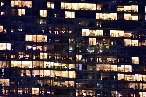 Office building at night. Late night at work. Glass curtain wall office building