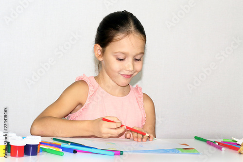 little girl draws with colored pencils, child and creativity