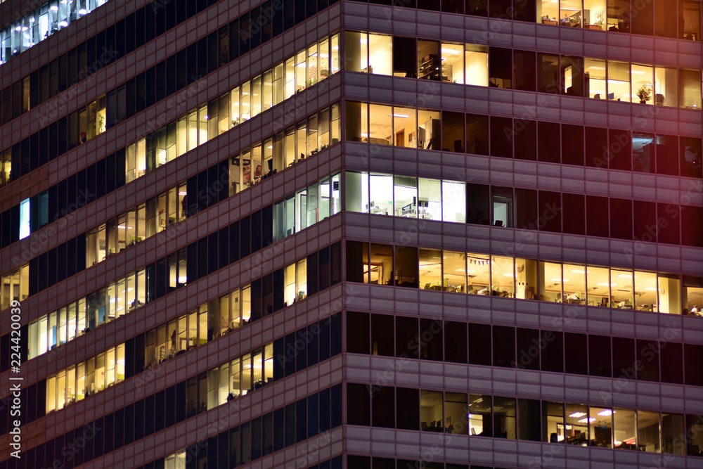 Obraz premium Office building at night. Late night at work. Glass curtain wall office building