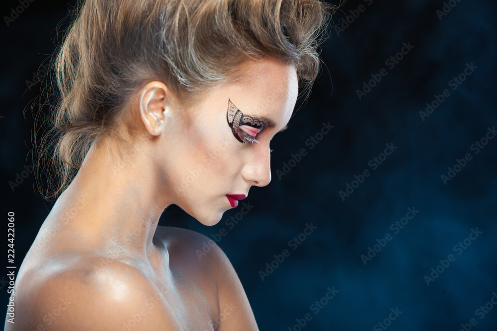 Electronic cigarette wiper. Halloween. Portrait of young beautiful girl with make-up. E-cigarette smoke, Viper. Isolated on black background.