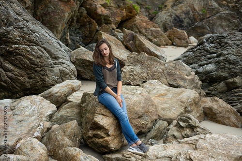 portrait d une jeune femme sur une plage au milieu des rochers 