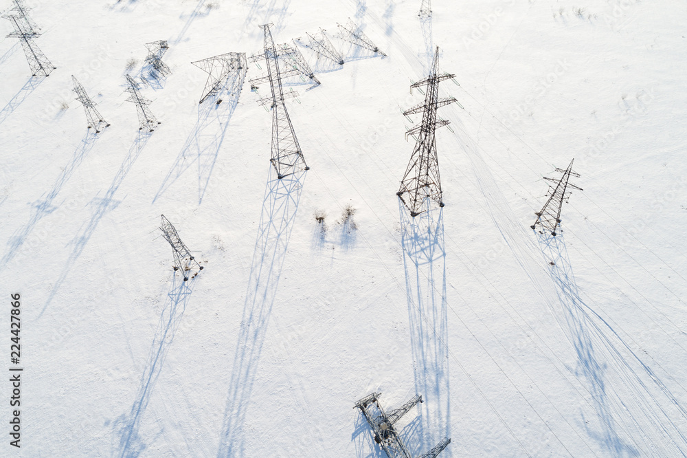 Aerial view of power line pillars in snow field