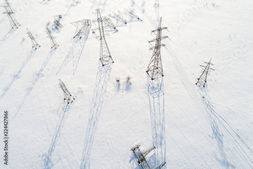 Obraz na płótnie Aerial view of power line pillars in snow field w salonie