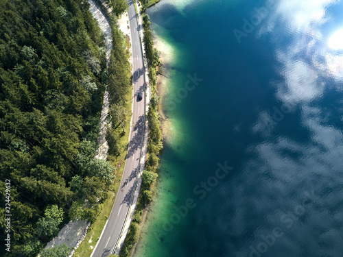 Aerial view of the road near the lake and the forest from above © visualitte