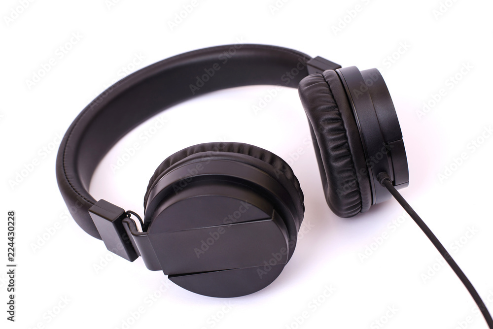 Low-angle closeup photo of classy classic mat frosted textured dark black headphones with cable copy-space isolated on white background Low-angle closeup photo of classy classic mat frosted textured dark black headphones with cable copy-space isolated on white background