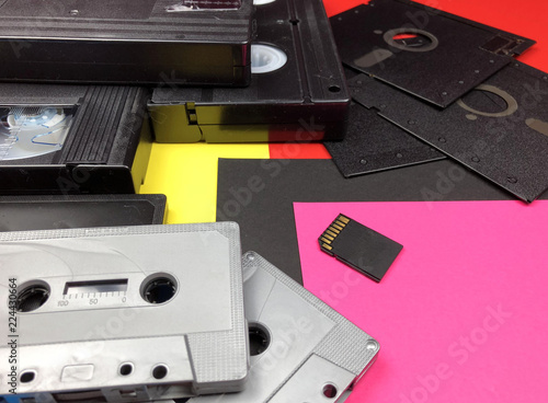 Tapes, floppy disk and memory card on colorful background. Old and modern technology.