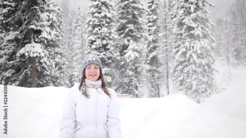Girl throws snow up. Portrait of the beautiful girl throwing snow in the winter. Happy young woman plays with a snow in sunny winter day. the girl is smiling at the camera. Girl throws snow up. Portrait of the beautiful girl throwing snow in the winter. Happy young woman plays with a snow in sunny winter day. the girl is smiling at the camera.