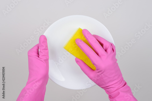 Staff clear cloth people person family dinner concept. Overhead top above close up minimal cutout photo of lady's hands cleaning round plate using yellow sponge isolated on gray background copy-space