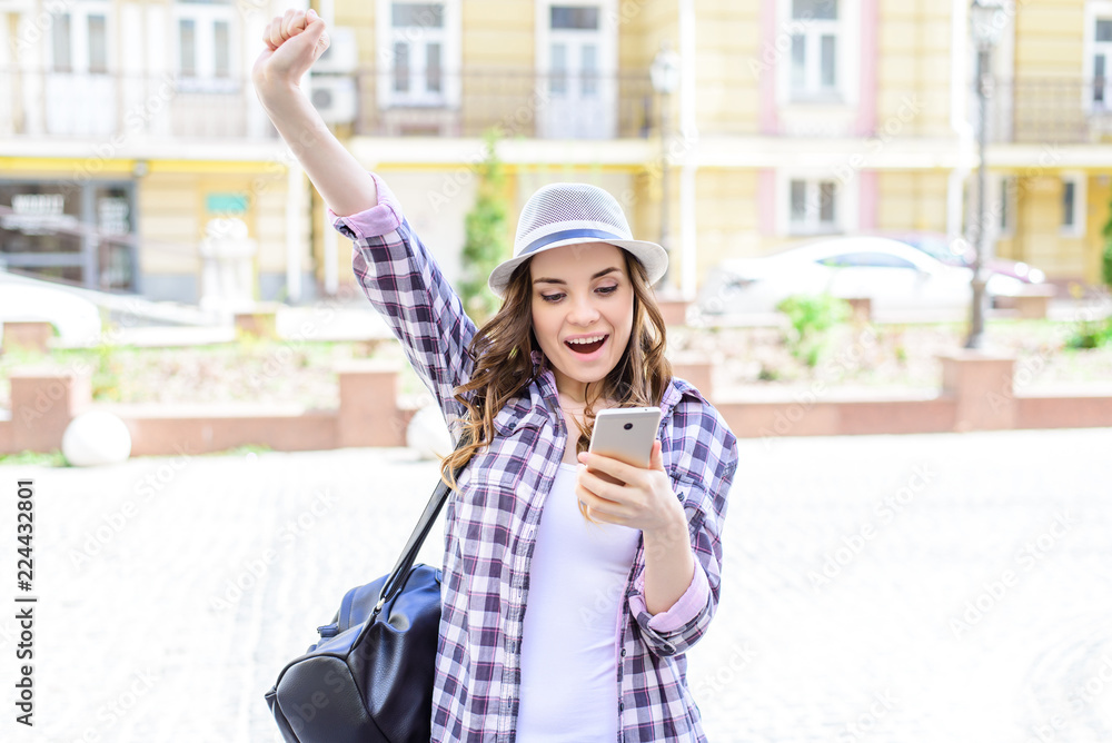 Facial emotion expressing chat connection roaming internet good news concept. Portrait of pretty beautiful glad cheerful rejoicing lady raising hands up looking at phone in hands receiving sending sms