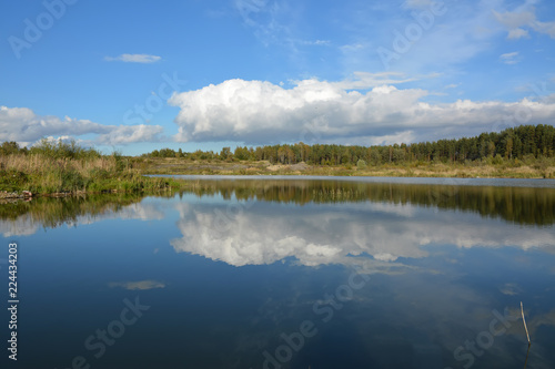 Sunny autumn day on the shore of an artificial lake.