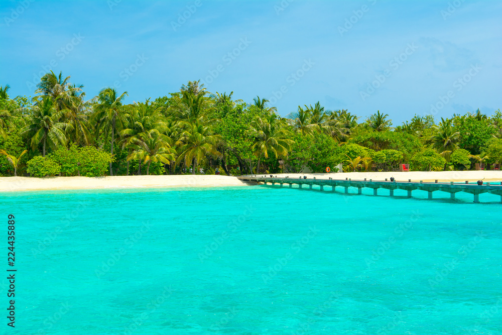 Beautiful sandy beach with sunbeds and umbrellas in Indian ocean, Maldives island Beautiful sandy beach with sunbeds and umbrellas in Indian ocean, Maldives island