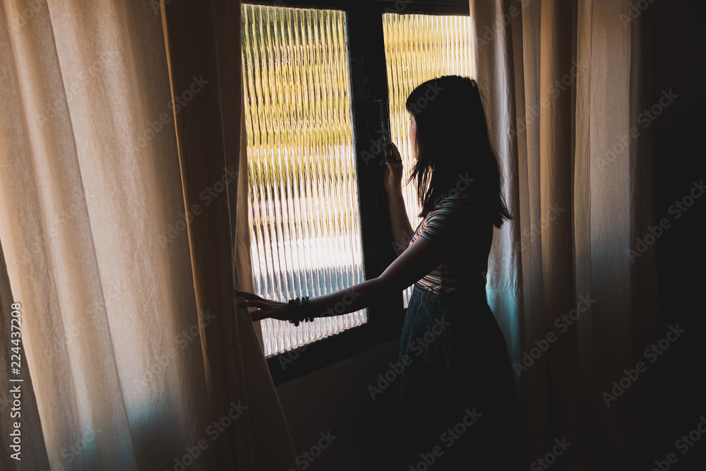 Fototapeta premium woman looking through window