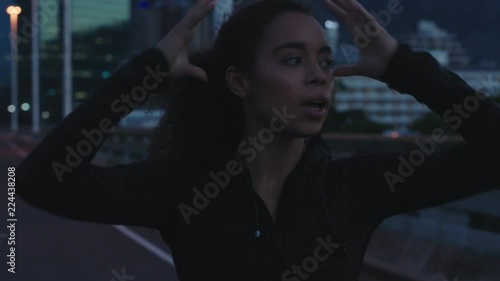 young woman runner athlete on city street resting after running exercise workout in urban at night