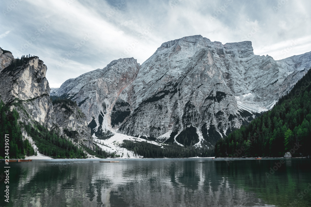 Fototapeta premium Pragser Wildsee in the summer from a long distance with clouds and dark colors