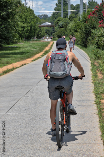 The Atlanta BeltLine (path/greenspace) with unidentifiable people biking and walking on a warm summer afternoon