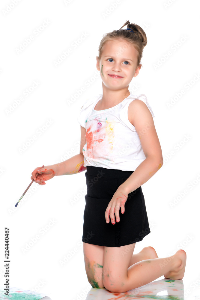 A little girl paints with paint and brush. A little girl paints with paint and brush.