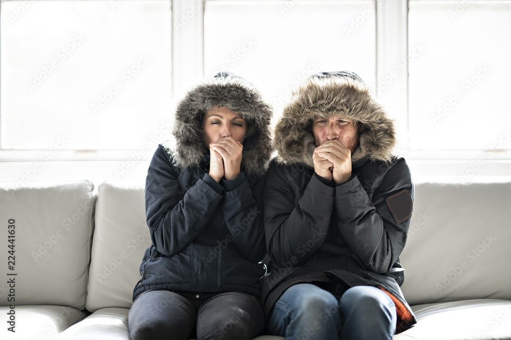 Couple have cold on the sofa at home with winter coat - obrazy, fototapety, plakaty 