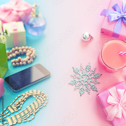 Festive composition set of boxes with gifts jewelry perfume mobile phone cocktail Christmas decorations The view from the top of the gradient background pink blue flat lay
