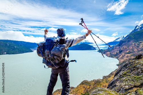 Homme sac á dos avec batons de randonnée en l'air en Patagonie Torres Del Paine Chili sport aventure photo