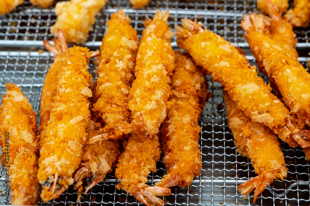 The crisp and tender taste of fried shrimps are stacked on deep fryer to reduce oil and temperature for easy eating.