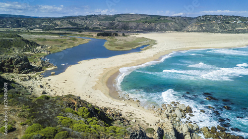 An aerial drone view over Tunquen Beach in Valparaiso region and close to Algarrobo, an awesome beach with a lot of wildlife because of it wetlands and turquoise waters, an idyllic travel destination photo