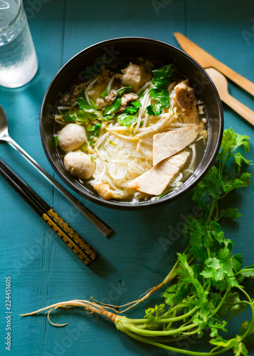 asian rice noodle soup with pork and meat ball on table photo