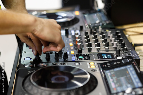 DJ mixing tracks on professional DJ sound controller