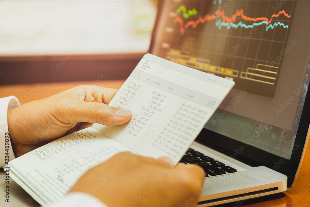 Naklejka premium Businessman hands holding saving account passbook with stock money cahrt.