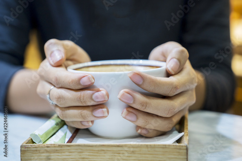 Young woman hands holding hot cup of coffee