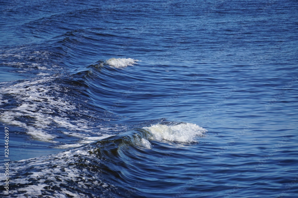 Patterns of waves in blue water, in the wake behind a boat. Patterns of waves in blue water, in the wake behind a boat.