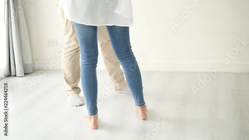 Couple's legs dancing at home together, slow motion.