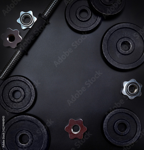 A parts of bumbbells and weights on black background. Power training concept.