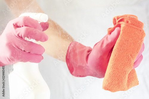 Photos shot through glass hands with rag and spray bottle cleaning glass housekeeping c