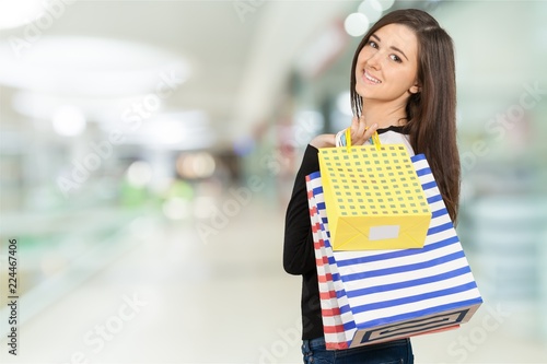 Young woman with shopping bags on blurred shopping mall