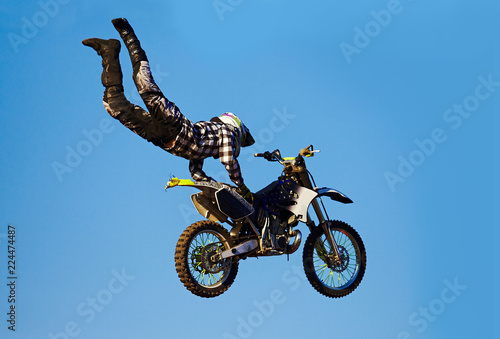 Pro motocross rider riding fmx motorbike, jumping performing extreme stunt. Professional biker jumps