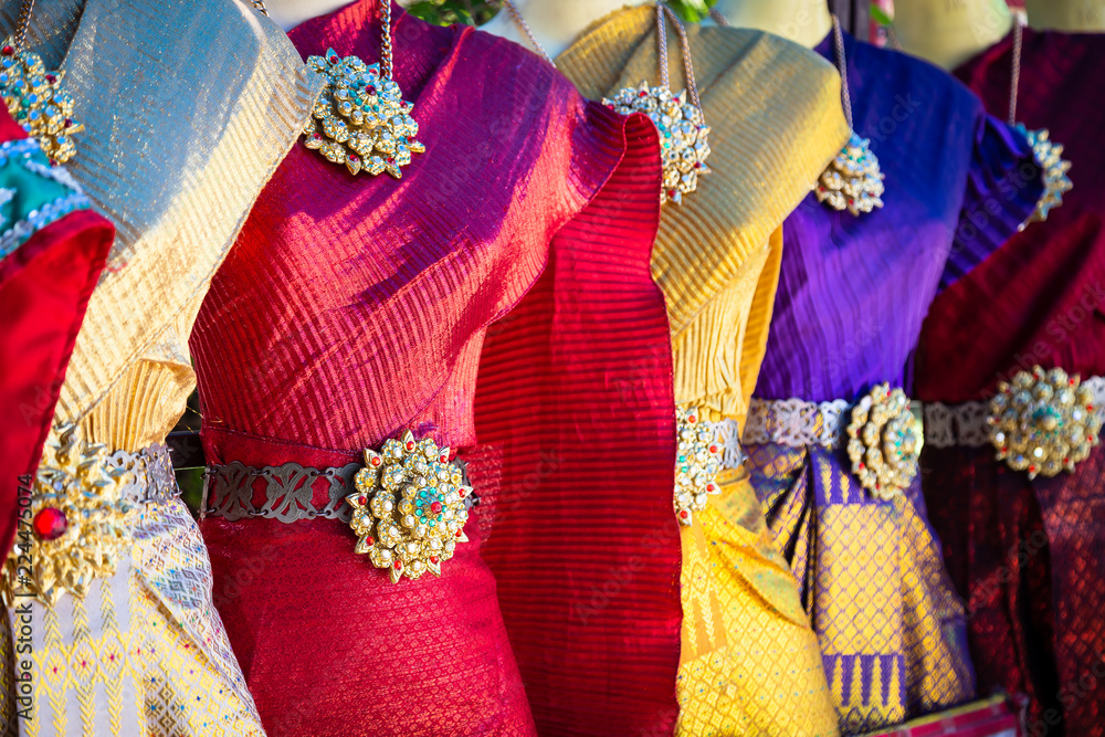 Vibrant traditional Thai silk dresses and accessories display